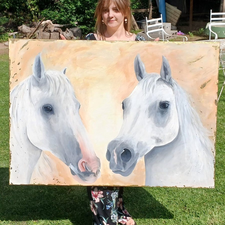 Hope holding her painting of two white horses