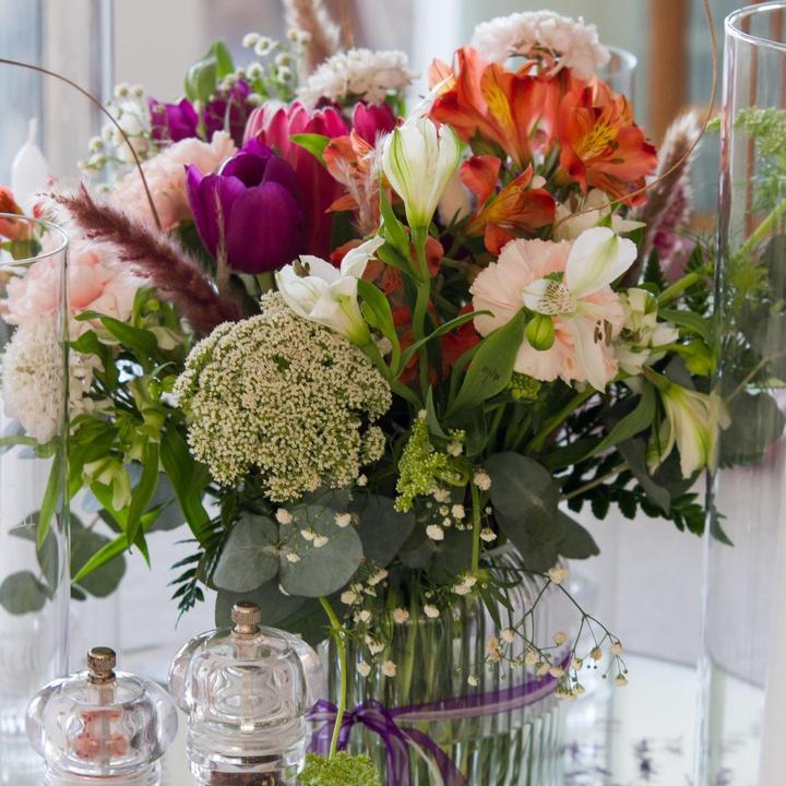 Bright mixed wedding table arrangement in glass