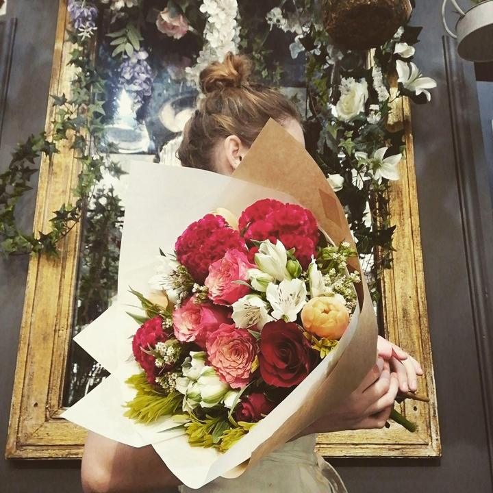 Hope holding a wrapped bouquet of roses