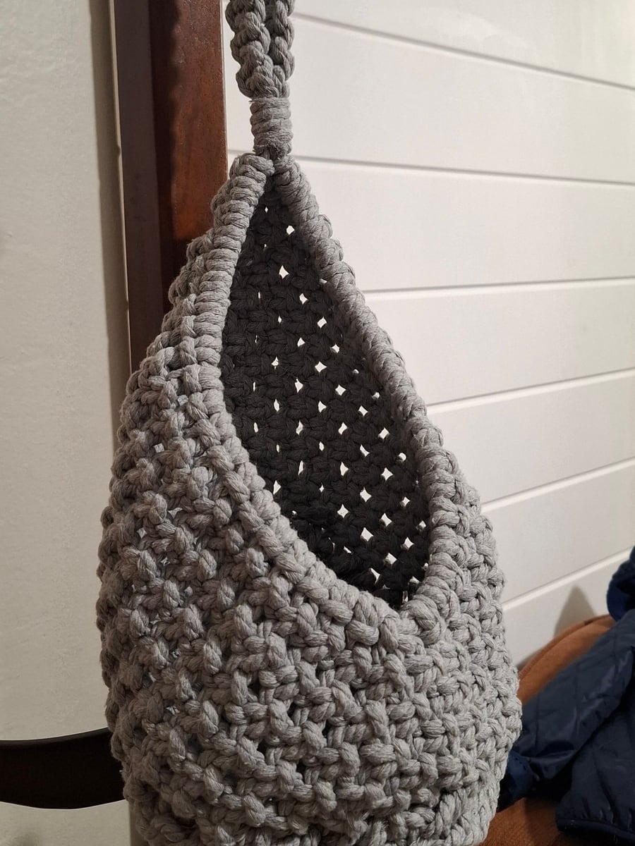 Grey macramé hanging basket on a wooden coat stand